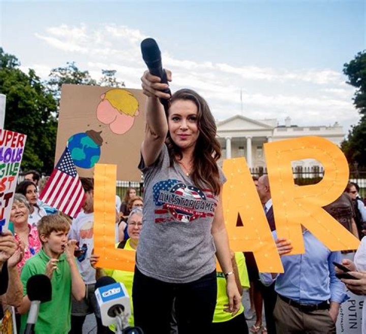 Actress Alyssa Milano holds out her microphone as she starts a chat while speaking at a protest outside the White House, in Washington. This is the second day in a row the group has held a protest following President Donald Trump's meetings with Russian President Vladimir PutinTrump, Washington, USA - 17 Jul 2018