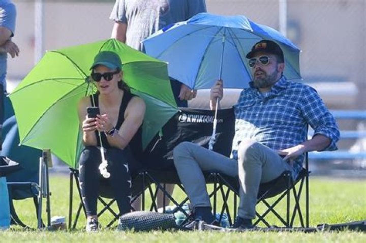 Ben Affleck & Jennifer Garner Shade Themselves With Umbrellas As They Watch Daughter’s Soccer Practice Together