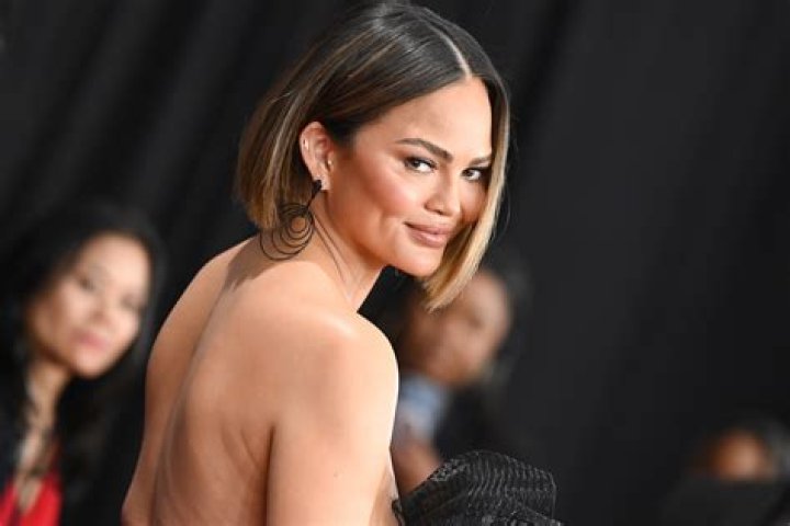 Chrissy Teigen Dresses As A Hooters Girl In Tank & Short Shorts As She Reveals She Once Worked There