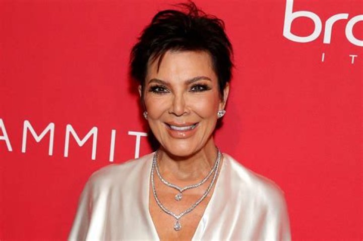 Kris Jenner smiling with snakeskin gloves