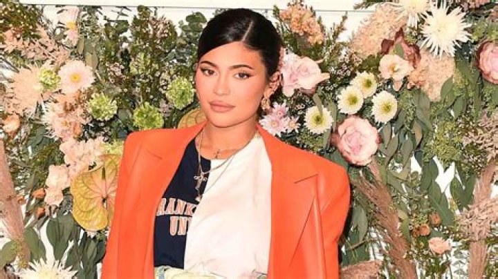 Kylie Jenner Cradles Her Baby Bump & Channels Kim Kardashian In All-Red Look — Watch