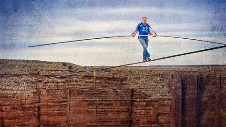 Nik Wallenda steps over his sister Lijana Wallenda as they perform on a tightrope before the NASCAR Sprint Cup Series auto race at Charlotte Motor Speedway in Concord, N.C., Saturday, Oct. 12, 2013. (AP Photo/Chris Keane)