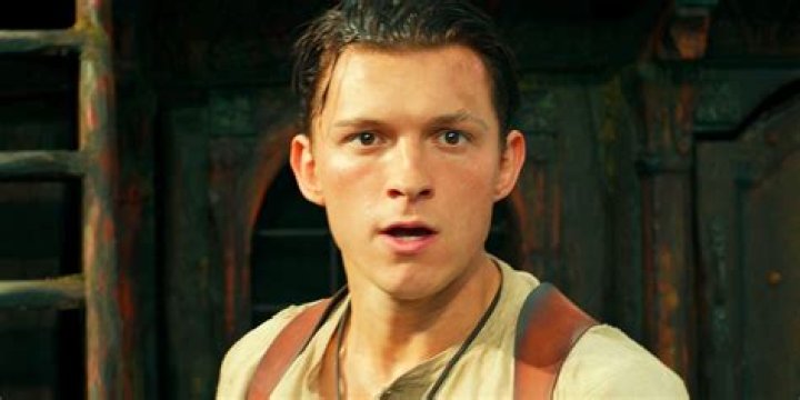 Tom Holland in backwards hat and grey shirt
